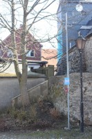 Kurz unterhalb der Mastspitze geht das kabel nach links ab. Es führt zum Giebel mit der braunen Holzverschalung.