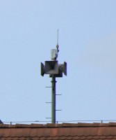 ... und hier in voller Größe. Deutlich erkennbar die Antenne zur Auslösung über BOS-Funk. Die Hörner überragen nur knapp die Dachkante, deshalb ist die Anlage überhaupt nicht zu sehen, wenn man vor dem Gebäude steht. - Sorry für die schlechte Bildqualität, ich musste mein Tele ganz ausreizen und das dann freihändig...